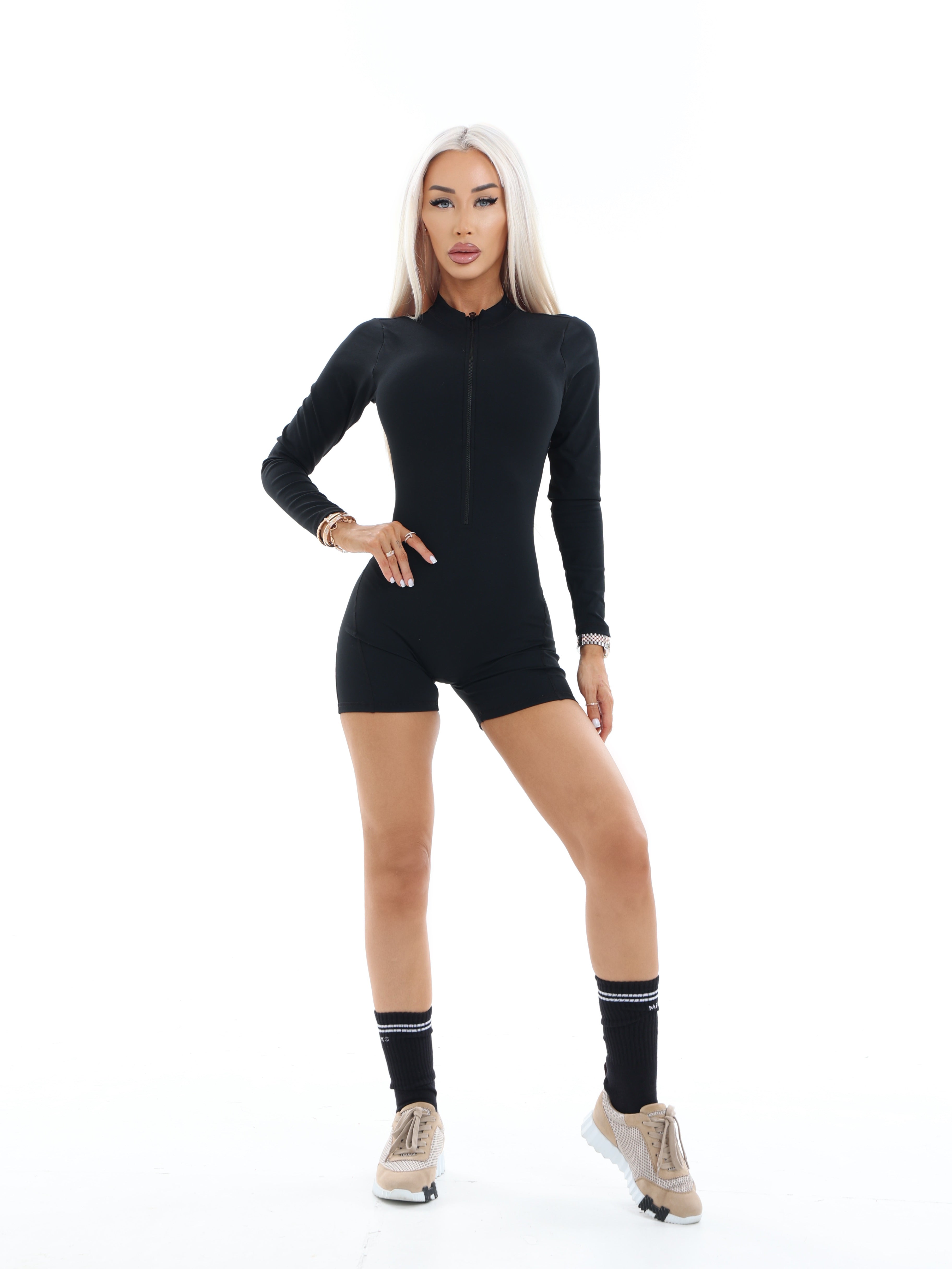 Person wearing a black activewear bodysuit on a white background