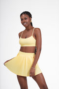 Woman wearing a yellow Lumia' Top and skirt on a white background