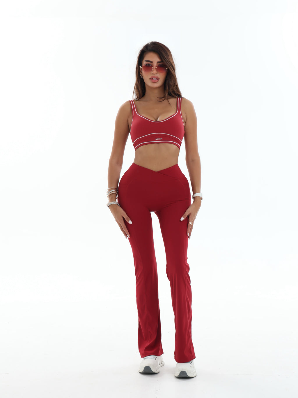Woman wearing a red activewear outfit on a white background