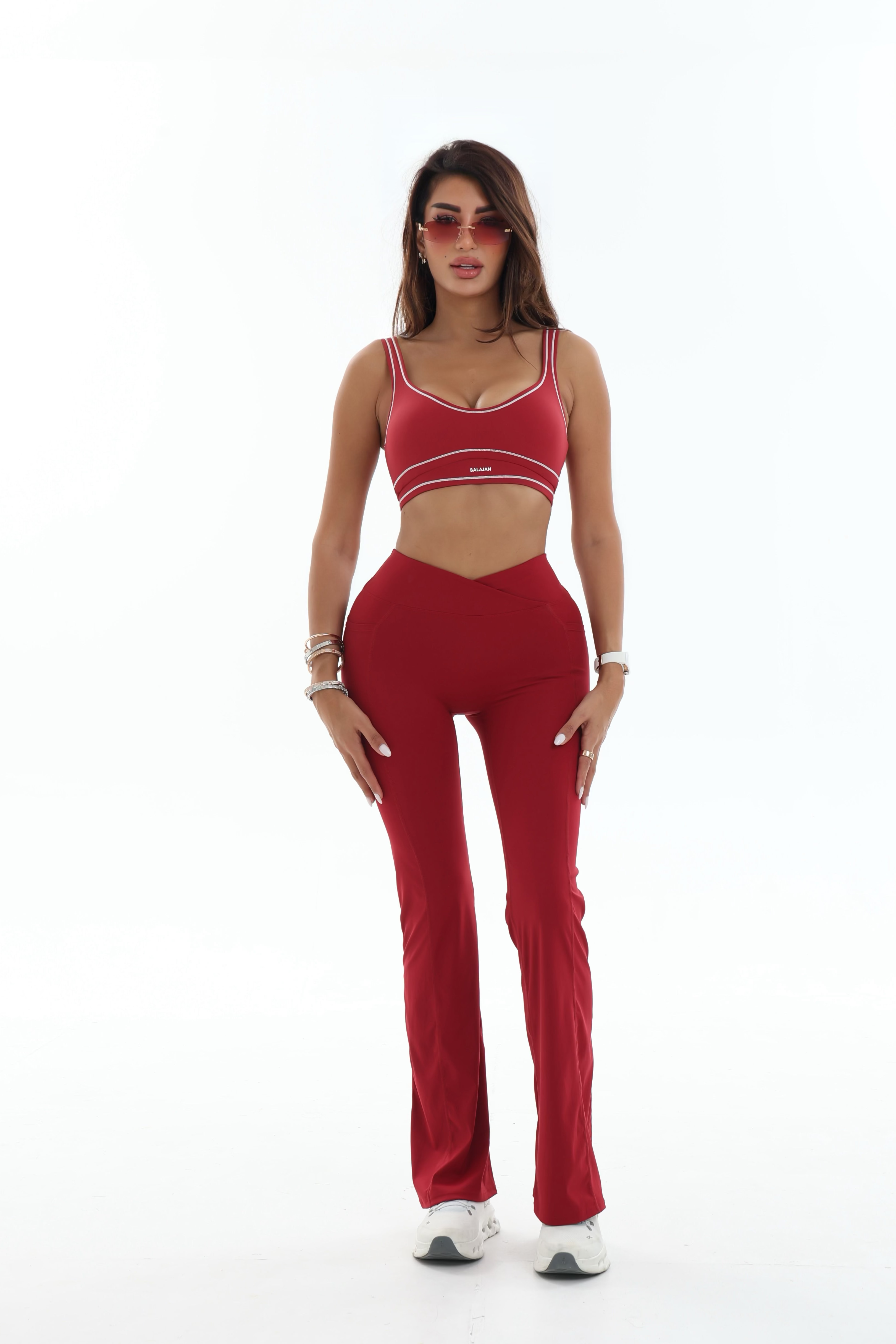 Woman wearing a red activewear outfit on a white background