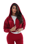 Woman wearing a red activewear hoodie on a white background