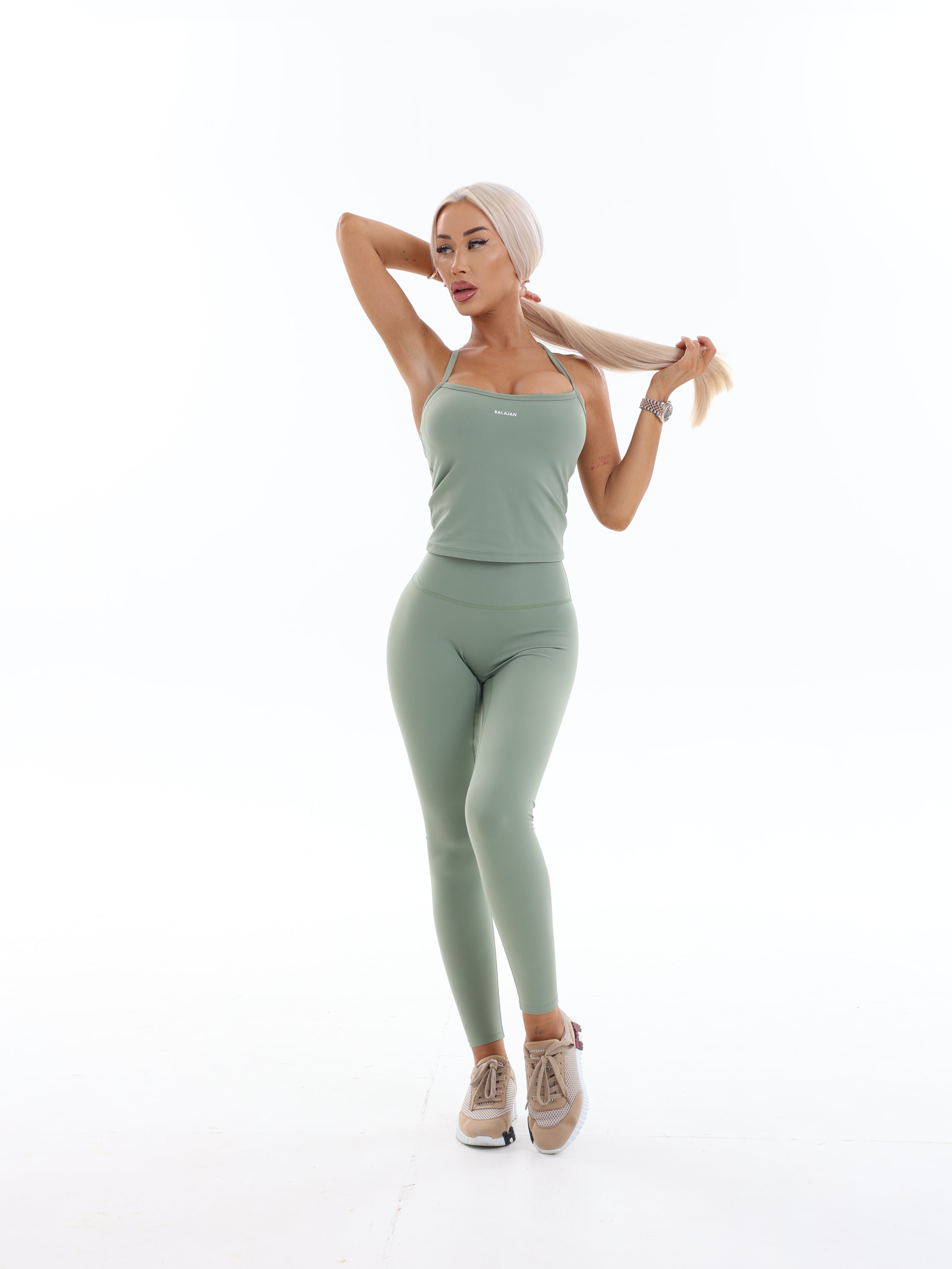 Woman in green athletic Sculpt Leggings on a white background