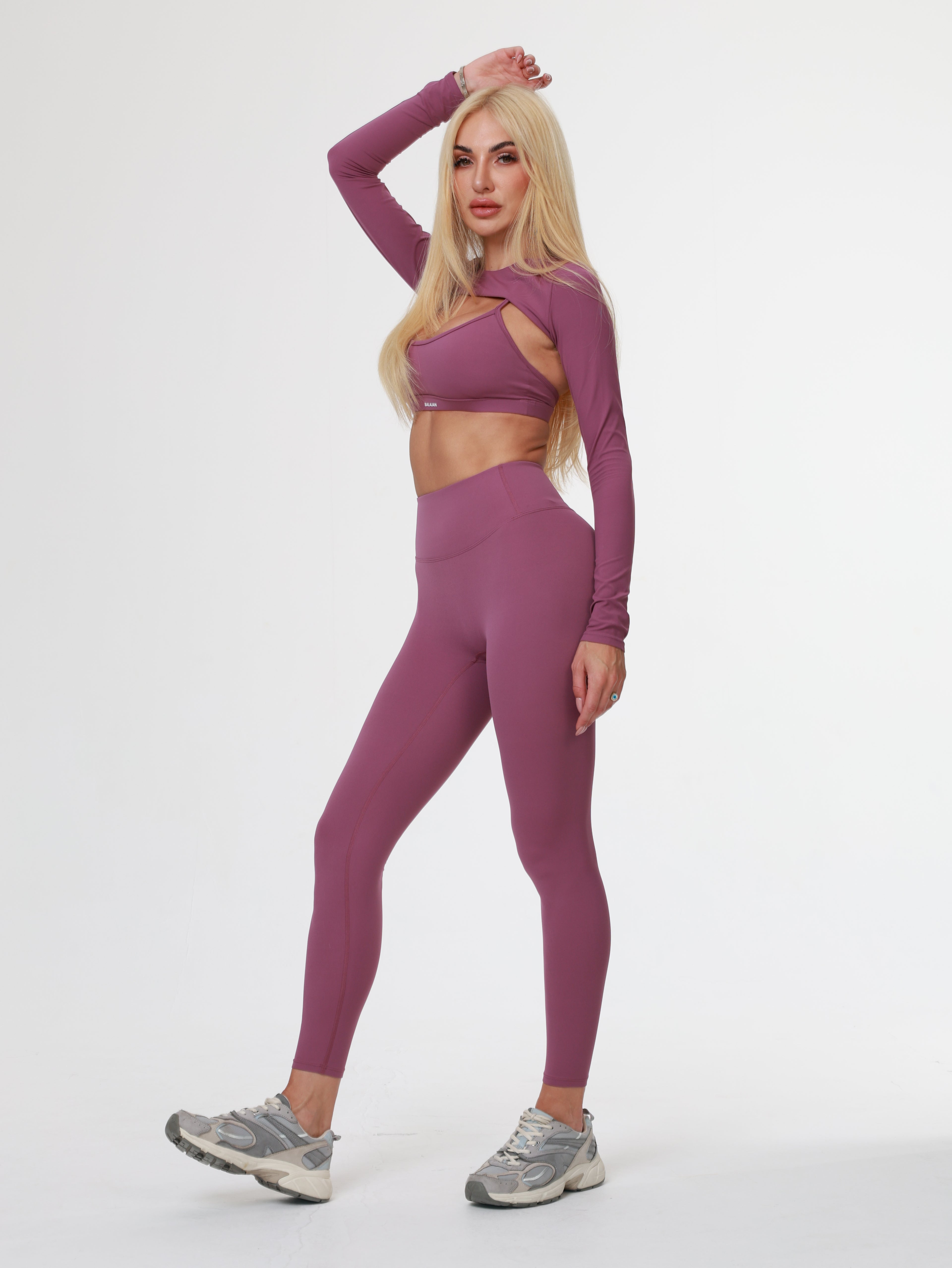 Person wearing a purple athletic Amethyst Leggings posing on a white background