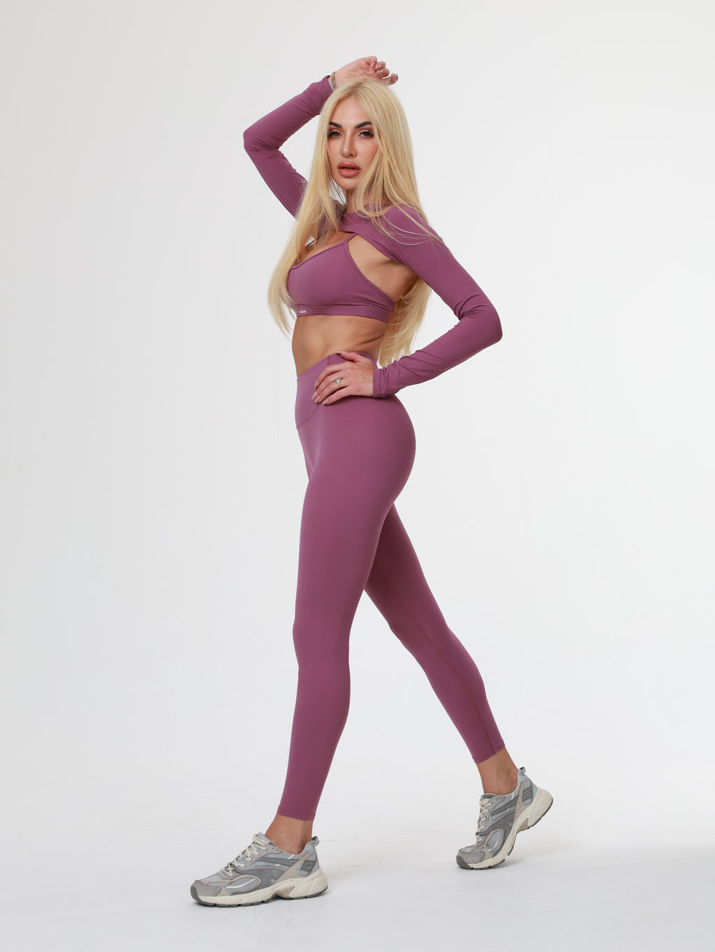 Woman in purple Amethyst Leggings wear posing on a white background