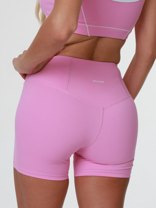 Person wearing activewear pink athletic Blush Babe Sculpt Shorts on a white background
