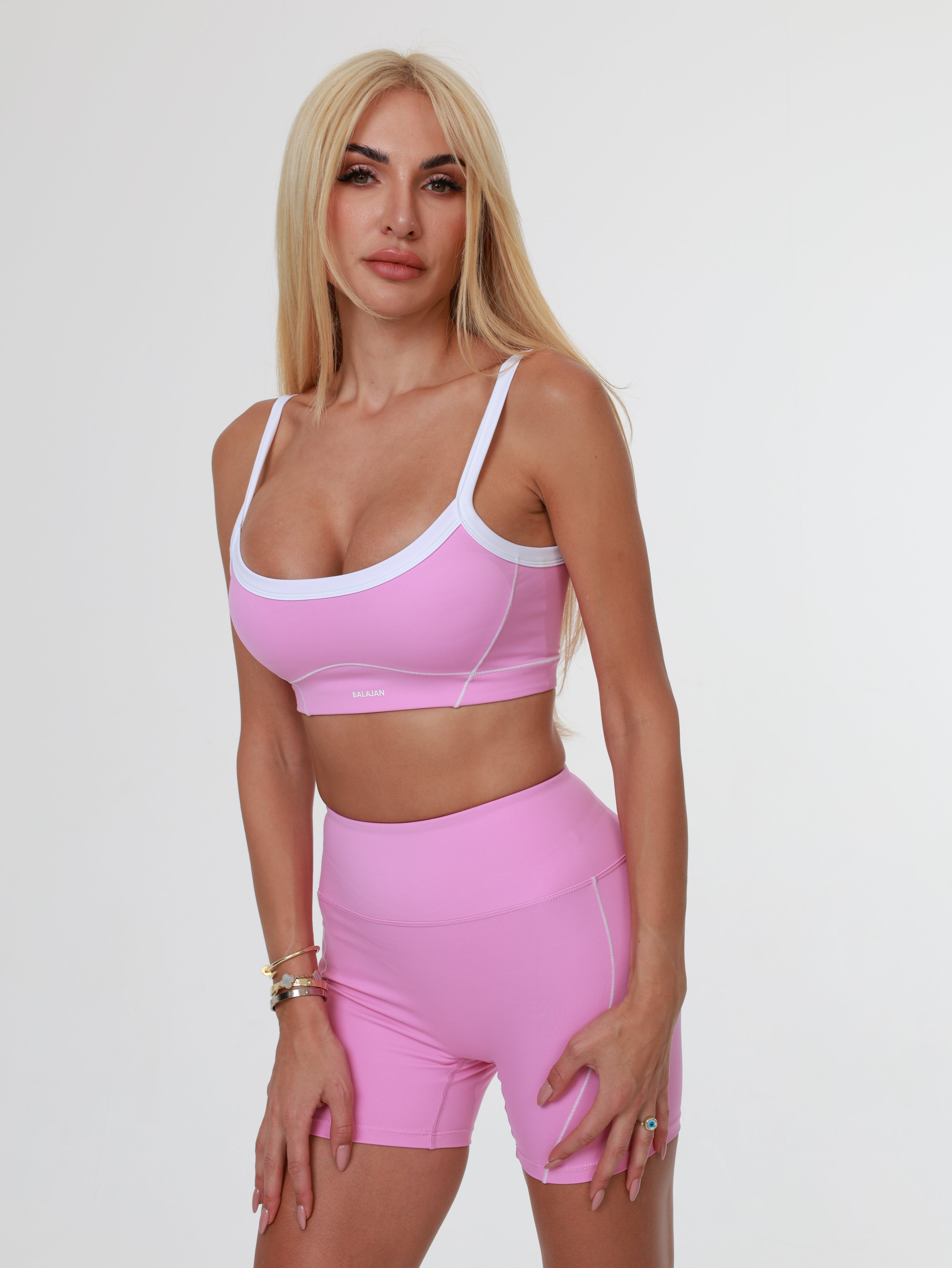 Woman wearing a pink Blush Babe Sculpt Shorts and bra on a white background