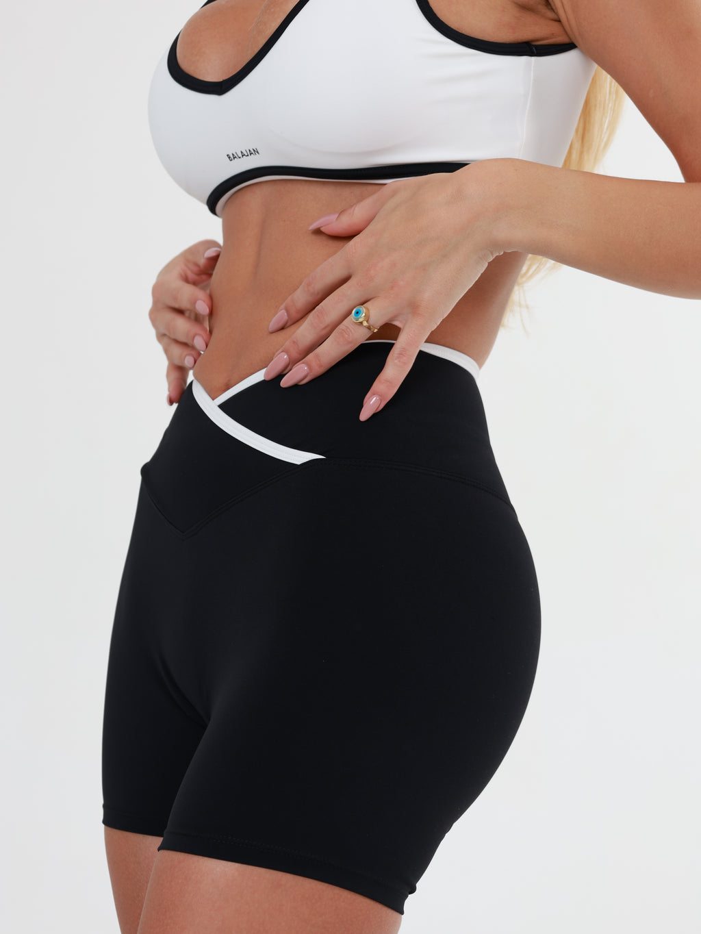 Person wearing black Eclipse-Glow Shorts and a white sports bra on a white background