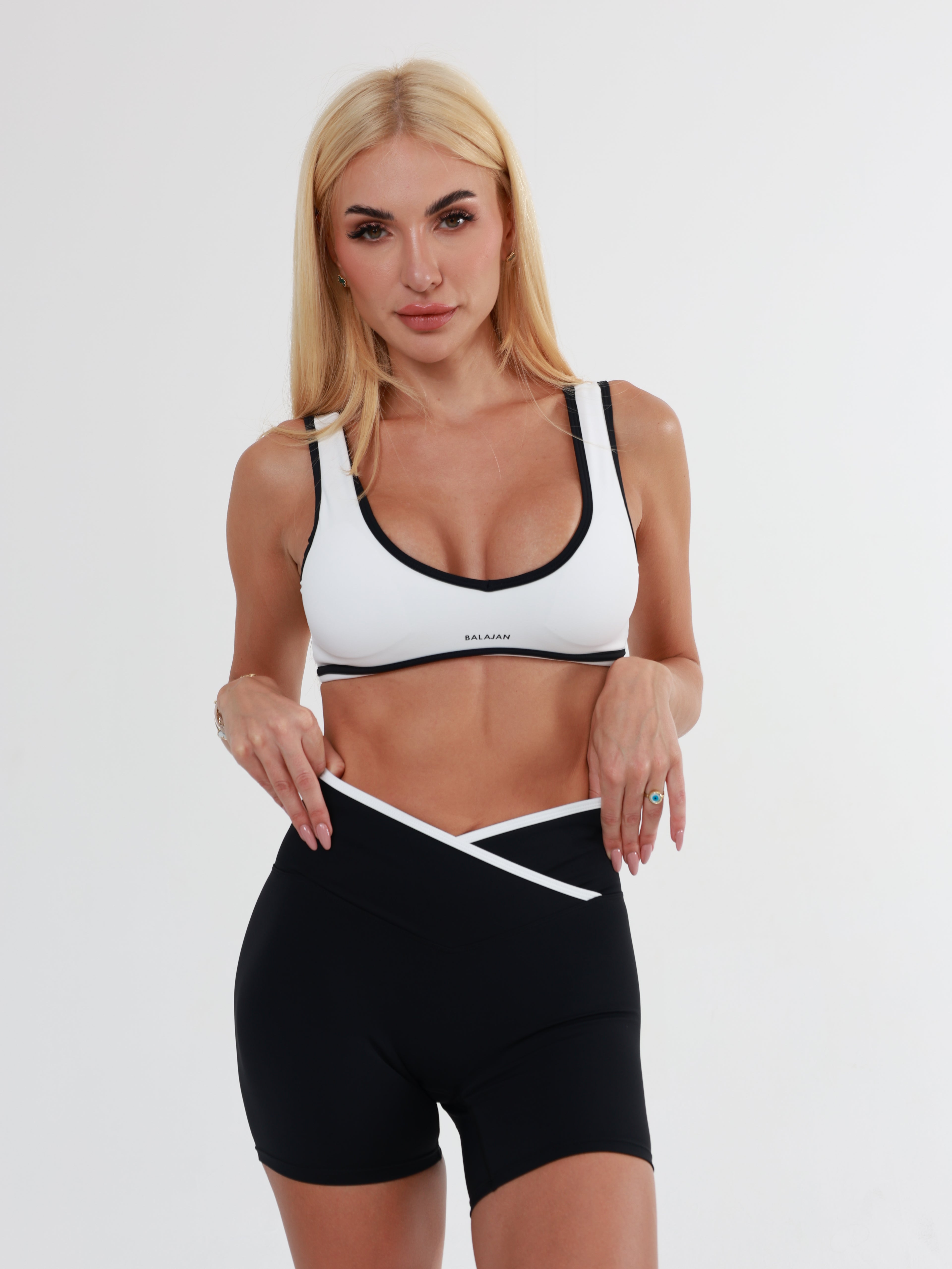 Woman wearing a black and white sports Eclipse glow Top  on a plain background