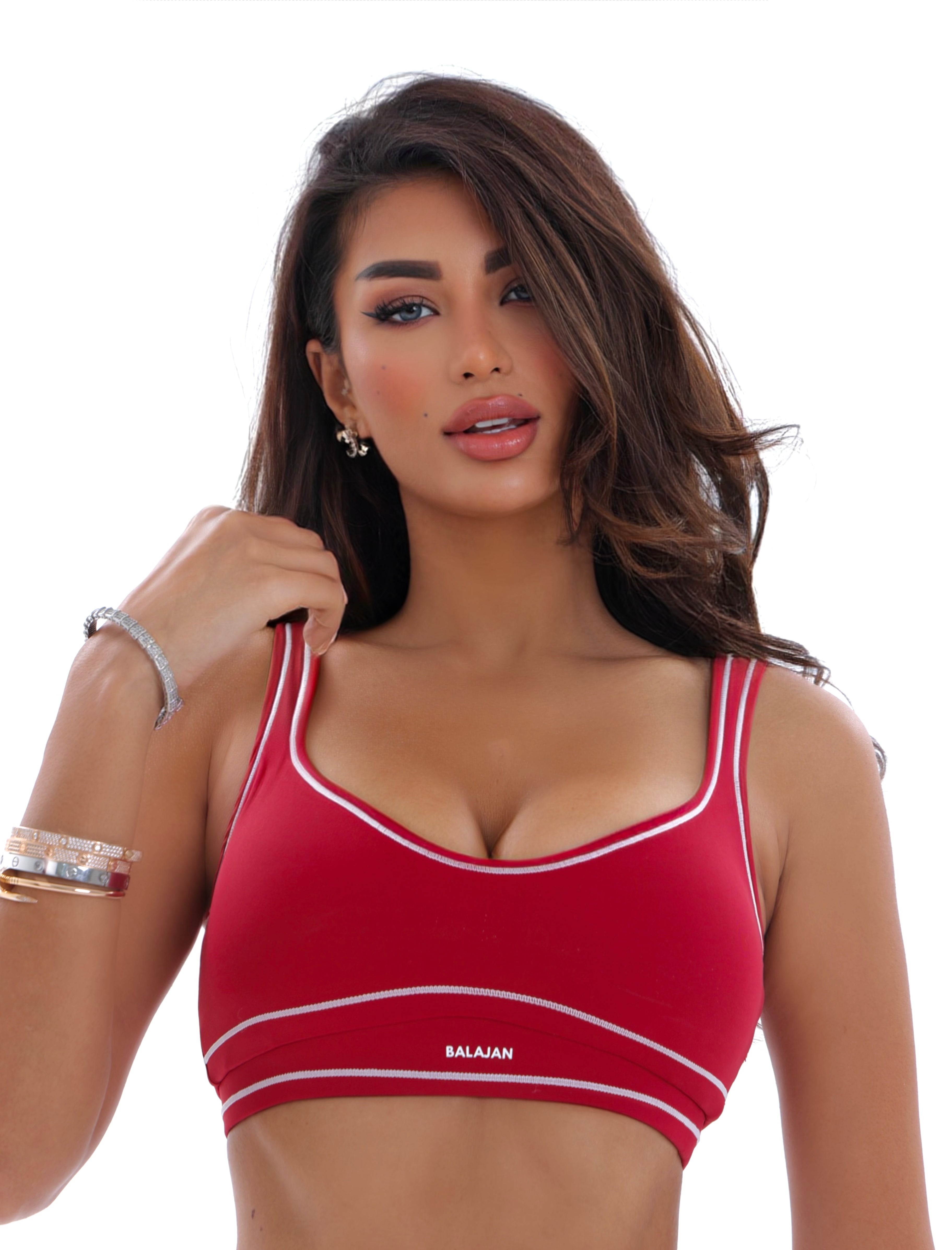 Woman wearing a red sports bra with 'Balajan' branding on a white background
