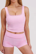 women wearing a pink tank top and shorts set on a white background