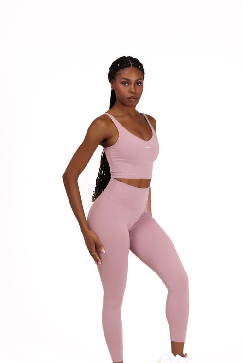 Woman wearing a pink athletic Core Sol Sculpt Top' on a white background