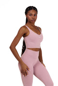 Woman wearing a pink athletic Core Sol Sculpt Top' on a white background