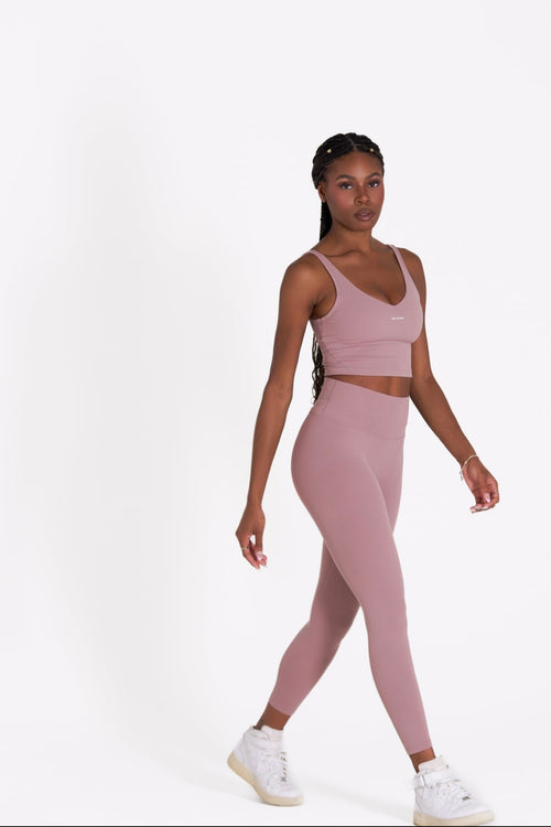 Woman wearing a pink athletic Core Sol Leggings' on a white background