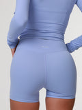 Person wearing a blue activewear outfit for women a light gray background